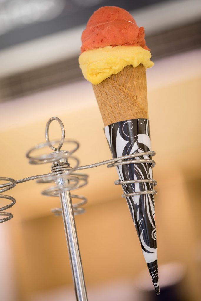 Cucurucho de dos bolas de helado italiano en el soporte de la heladería